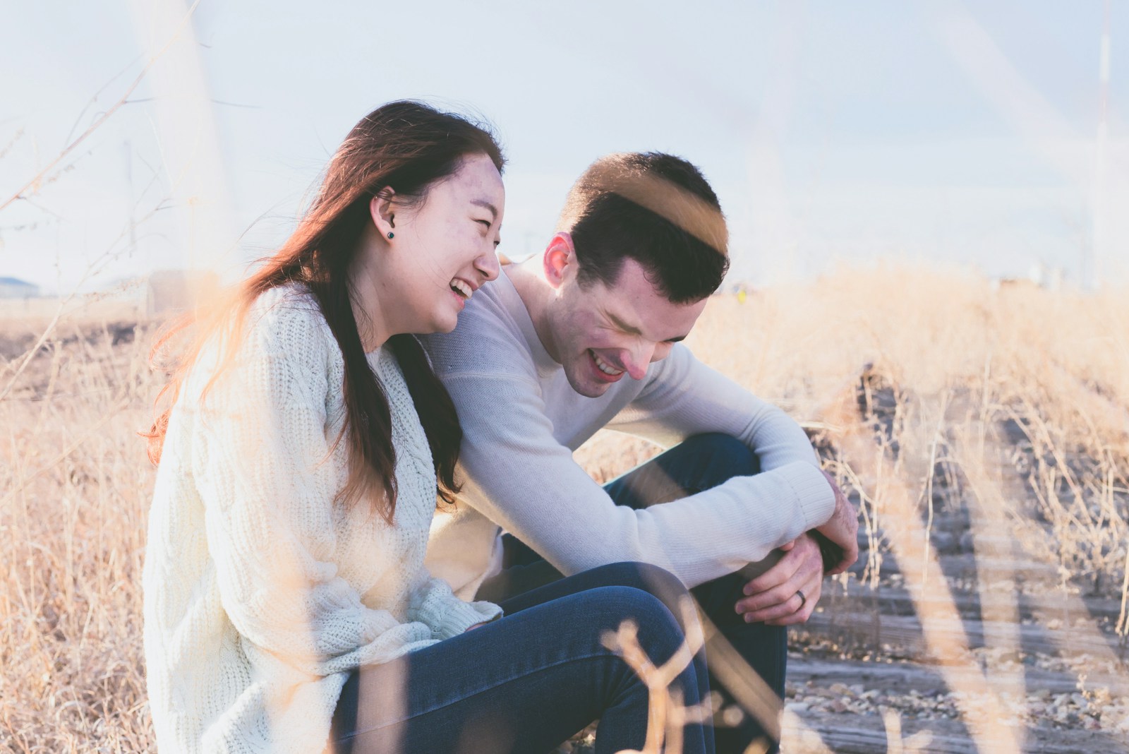 A woman and a man laughing together outdoors